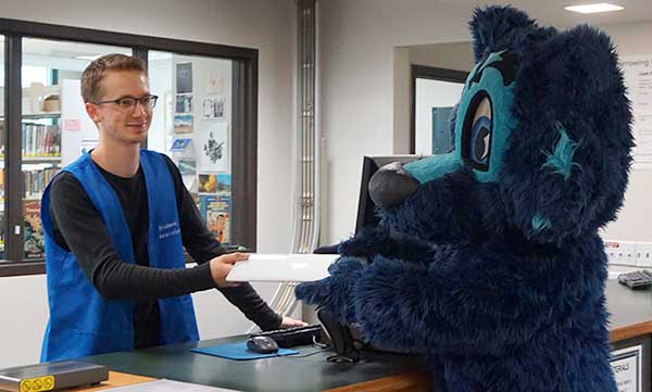 Lobo checking out a laptop at the Information Checkout Desk