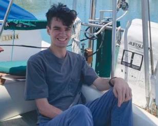 Smiling man sitting in a boat.