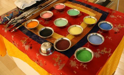 12 pot of different colored sand on a table.